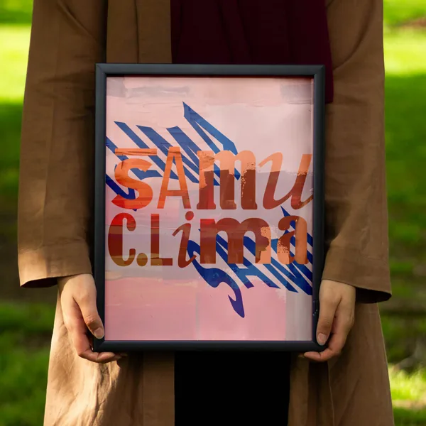 Person holding a framed Samu Clima logo print over blue brushstrokes