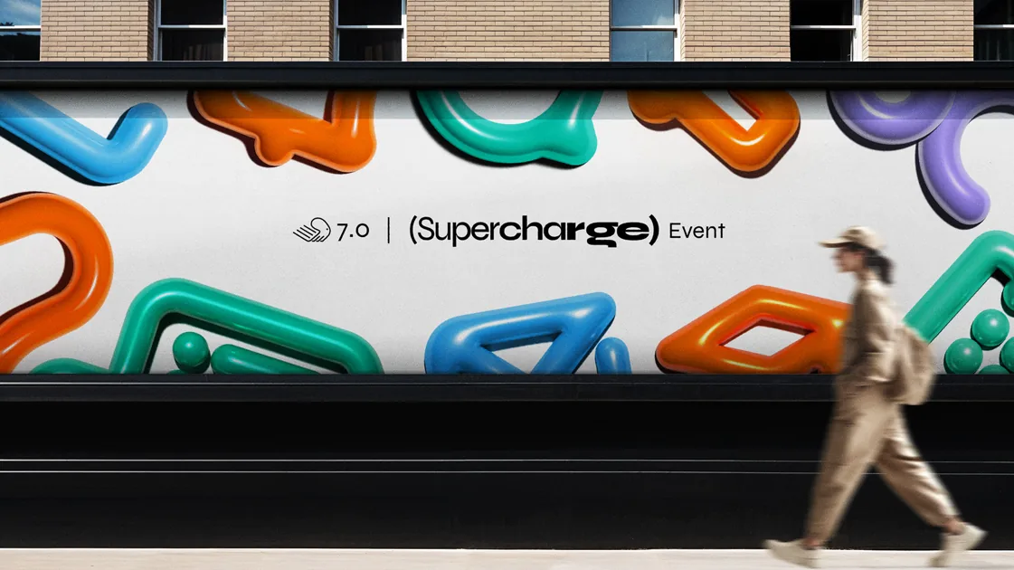 Street wall ad: “7.0 | (Supercharge) Event” among inflatable 3D shapes